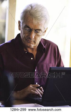 Stock Photo - desk, senior, computer, laptop, concentrating, business. Fotosearch