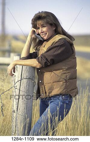 Stock Photo - fence, people, woman, autumn, telephone, talking, phone. Fotosearch