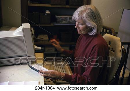 Picture - home, woman, senior, computer, finance, personal finance. Fotosearch