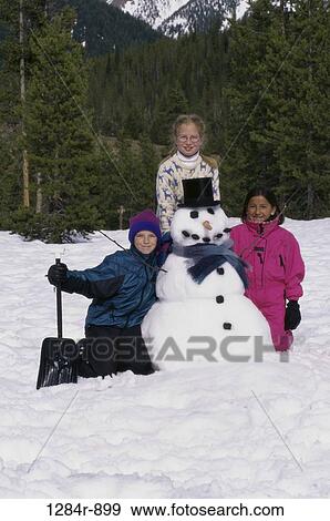 Stock Photo - multiethnic, people, snow, winter, carrot, shovel, trees. Fotosearch