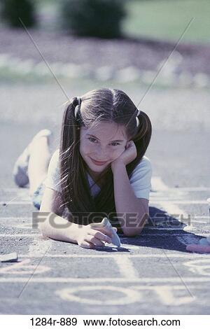 Stock Photo - people, chalk, girl, outdoors, child, draw, brunette. Fotosearch
