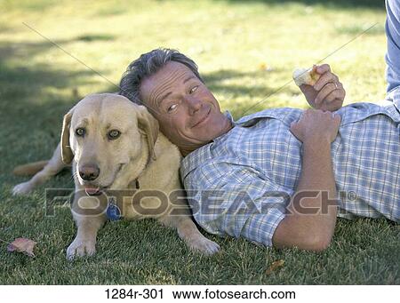 Stock Image - people, eating, dog, apple, pet, outdoors. Fotosearch