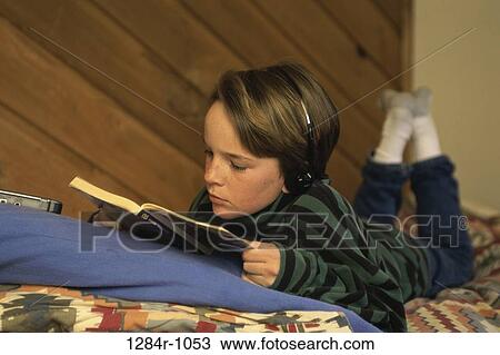 Stock Image - people, headset, listening, reading, book, boy. Fotosearch