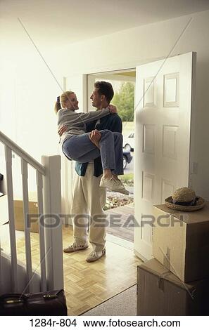 Picture - people, home, moving, new, couple, door, tradition. Fotosearch