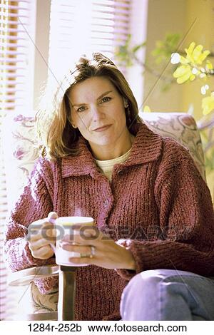 Stock Image - people, home, woman, coffee, mug, drinking, Middle-aged. Fotosearch