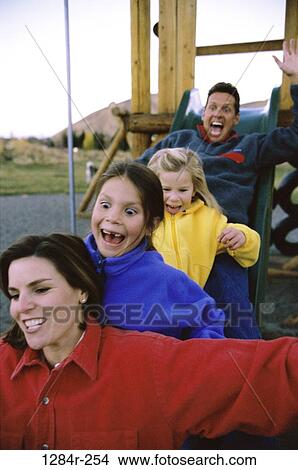 Picture - people, playing, excitement, excited, sliding, playground, outdoors. Fotosearch