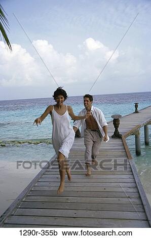 Stock Image - people, running, couple, beach, dock, clothed. Fotosearch