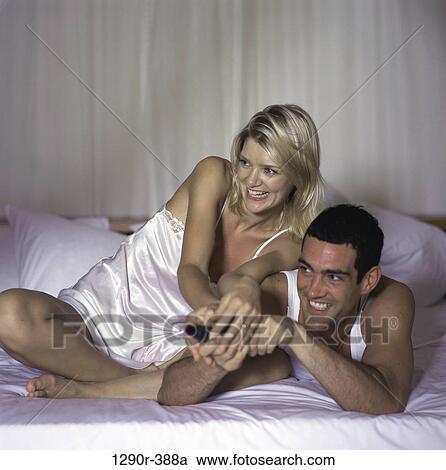 Stock Image - people, smiling, playing, couple, bed, watch. Fotosearch