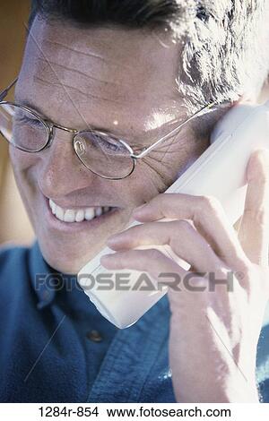Picture - people, smiling, telephone, talking, eyeglasses, phone, Middle-aged. Fotosearch