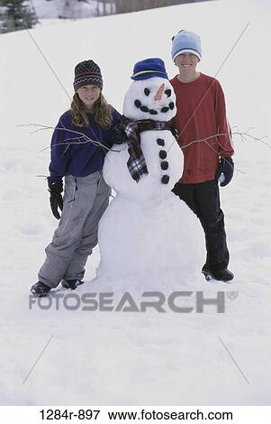 Stock Photo - people, snow, hats, winter, carrot, outdoors, children. Fotosearch