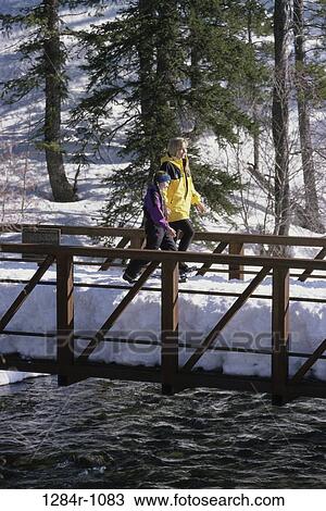 Stock Image - people, snow, water, walking, mother, winter, bridge. Fotosearch
