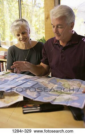 Stock Photo - people, table, couple, choices, window, map, senior. Fotosearch