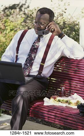 Stock Image - people, telephone, eyeglasses, bench, busy, computer. Fotosearch