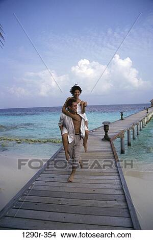 people, walking, couple, beach, playful, dock, piggyback View Large Photo Image Picture - people, walking, couple, beach, playful, dock, piggyback. Fotosearch
