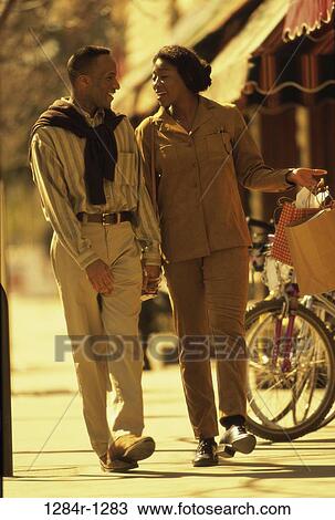 Stock Image - people, walking, couple, outdoors, Middle-aged, shopping, shop. Fotosearch