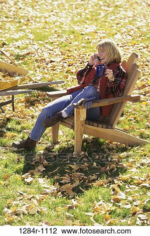 Stock Image - people, woman, autumn, telephone, talking, chair, sitting. Fotosearch