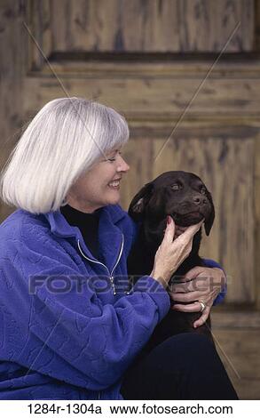 Stock Image - people, woman, dog, senior, pet, touching, animal. Fotosearch