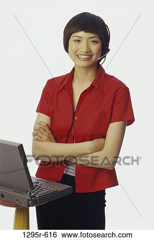Stock Photograph - people, woman, headset, Asian, computer, laptop, phone. Fotosearch