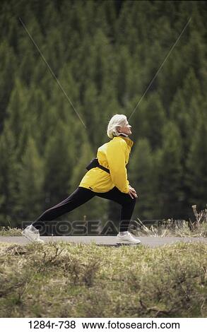 Stock Photo - people, woman, senior, stretching, outdoors, exercise, lunging. Fotosearch
