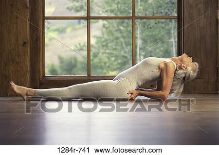 Stock Image - people, woman, window, senior, healthy, stretching. Fotosearch