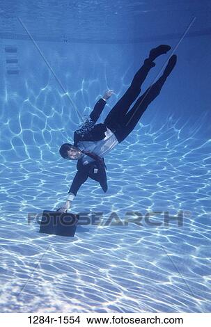Picture - swim, pool, briefcase, swimming, business, reaching. Fotosearch