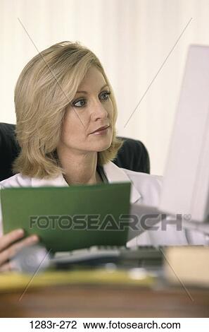Stock Image - woman, computer, doctor, chart, Middle-aged, indoors, Caucasian. Fotosearch
