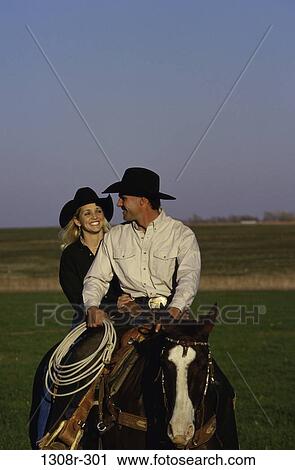 Stock Image - people, rope, couple, hats, riding, horse, outdoors. Fotosearch