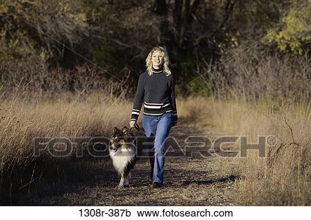 Stock Image - people, woman, autumn, walking, dog, pet. Fotosearch