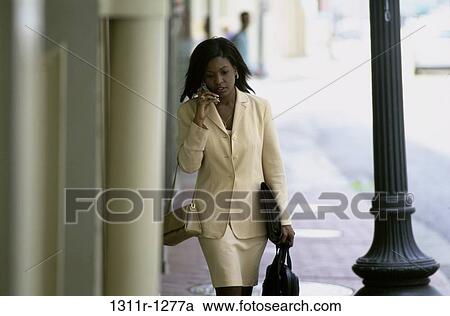 Stock Image - people, woman, telephone, walking, talking, phone. Fotosearch