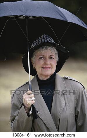 people, woman, umbrella, hat, rain, senior, outdoors View Large Photo Image Stock Image - people, woman, umbrella, hat, rain, senior, outdoors. Fotosearch