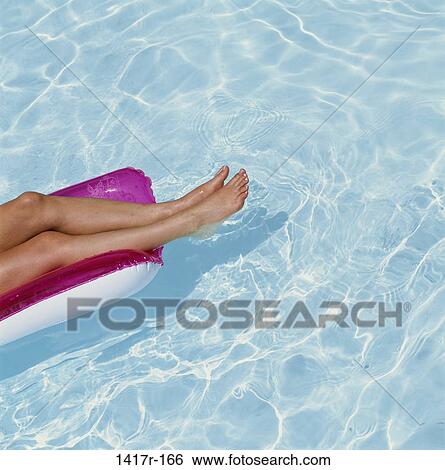 Stock Photograph - floating, water, pool, ripples, sunlight, raft, body parts. Fotosearch