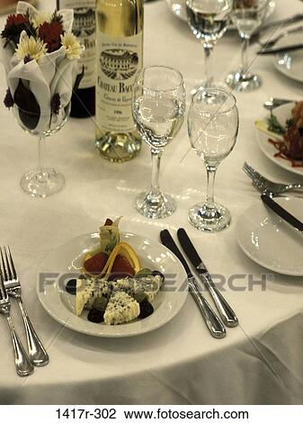 Stock Image - glasses, table, wine, plate, setting, flowers, arrangement. Fotosearch