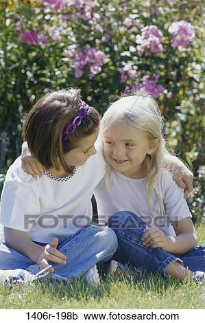 Stock Image - grass, people, smiling, friendship, sitting, outdoors, hugging. Fotosearch