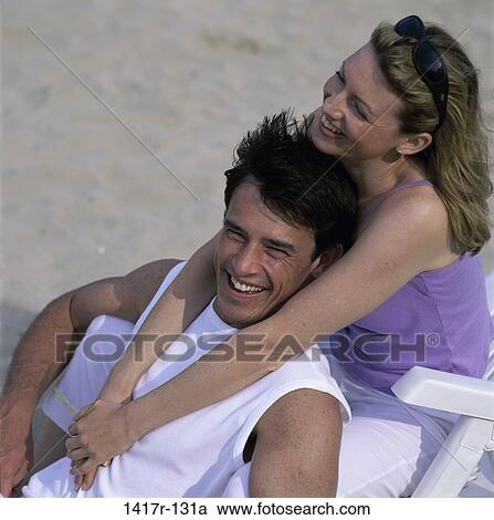people, couple, windy, wind, beach, hugging, chairs View Large Photo Image Stock Image - people, couple, windy, wind, beach, hugging, chairs. Fotosearch