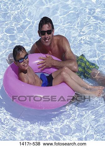 Stock Photo - people, floating, water, ripples, smiling, beach, sunglasses. Fotosearch