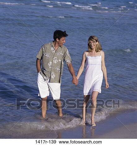 Stock Photo - people, walking, couple, beach, clothed. Fotosearch