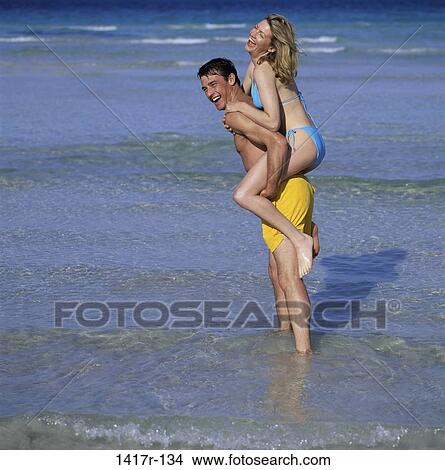 Picture - people, walking, couple, beach, piggyback. Fotosearch