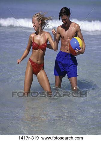 Stock Photo - people, water, playing, couple, ball, beach, dancing. Fotosearch
