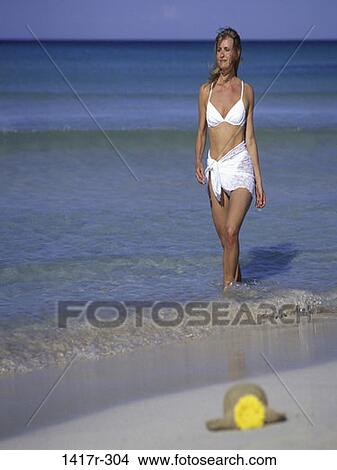 Picture - people, water, running, woman, hat, walking, ocean. Fotosearch