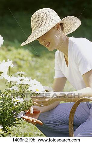 people, woman, smiling, hat, flowers, gardening, outdoors View Large Photo Image Stock Image - people, woman, smiling, hat, flowers, gardening, outdoors. Fotosearch