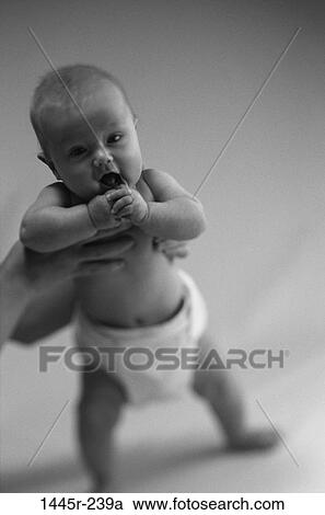 Stock Image - people, baby, holding, standing, stand, helping, black and white. Fotosearch