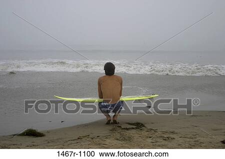 Stock Image - people, beach, back, contemplation, kneeling. Fotosearch