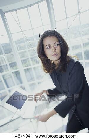 Stock Image - people, desk, woman, Hispanic, computer, laptop, business. Fotosearch