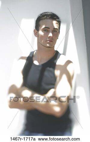 Stock Image - people, light, staring, arms, crossed, serious. Fotosearch