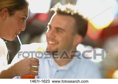 Stock Image - people, smiling, couple, drinking, straw, outdoors. Fotosearch