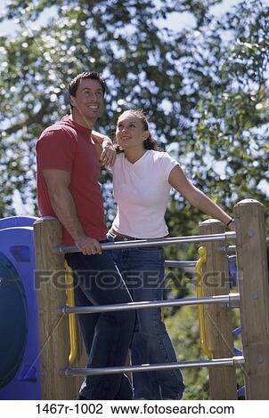 people, smiling, couple, playground, leaning, standing, outdoors View Large Photo Image Stock Image - people, smiling, couple, playground, leaning, standing, outdoors. Fotosearch