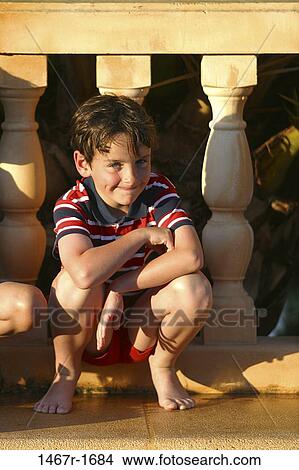 Picture - people, smiling, railing, sitting, boy, outdoors, smile. Fotosearch