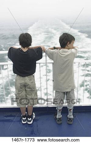 people, water, railing, beach, standing, waves, contemplation View Large Photo Image Stock Image - people, water, railing, beach, standing, waves, contemplation. Fotosearch
