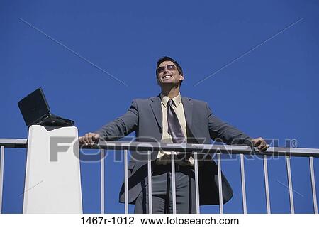 Stock Image - sky, smiling, railing, computer, laptop. Fotosearch