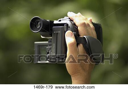 Stock Photo - hand, industry, holding, camera, video, hold. Fotosearch